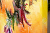 Detailed close-up of the abstract painting called 'The Shimmering Glade', by Annette Price. It depicts warm colours in yellows and oranges with the suggestion of a purple flower. The edge of the stretched canvas is in the foreground and shows how the painting continues on the edges of the canvas.